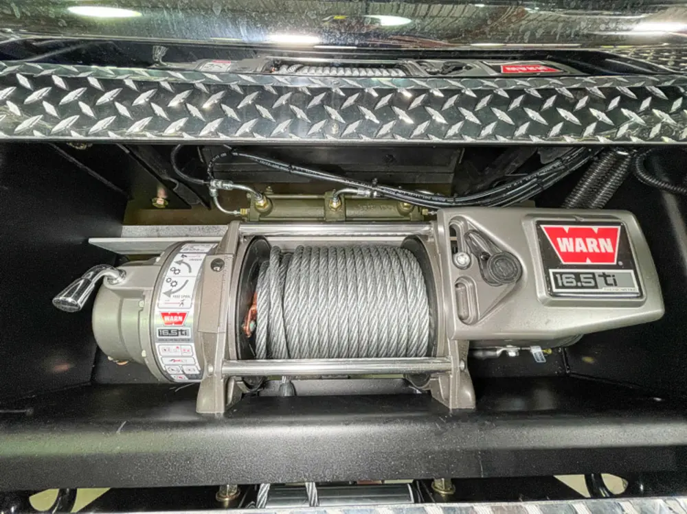 Exterior view of small fire truck showing cab, body compartments, and wheel/tire area.